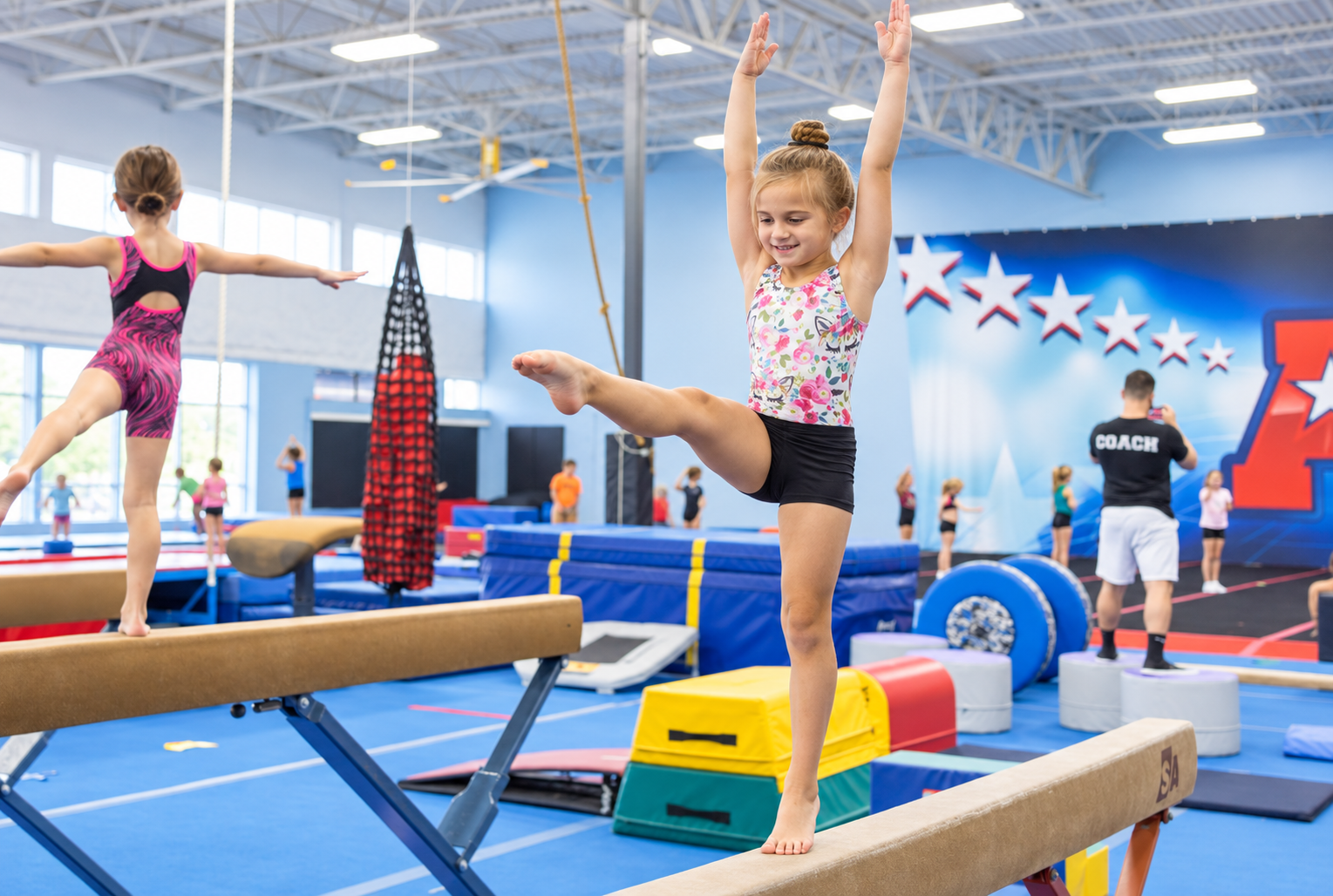 Smiling young gymnast balancing on one leg on a beam at All 4 Frisco